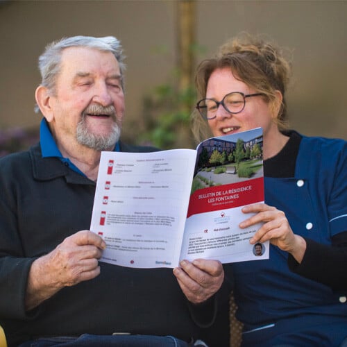 Un soignant et un résident avec leur bulletin interne - Un soignant et un résident avec leur bulletin interne -
