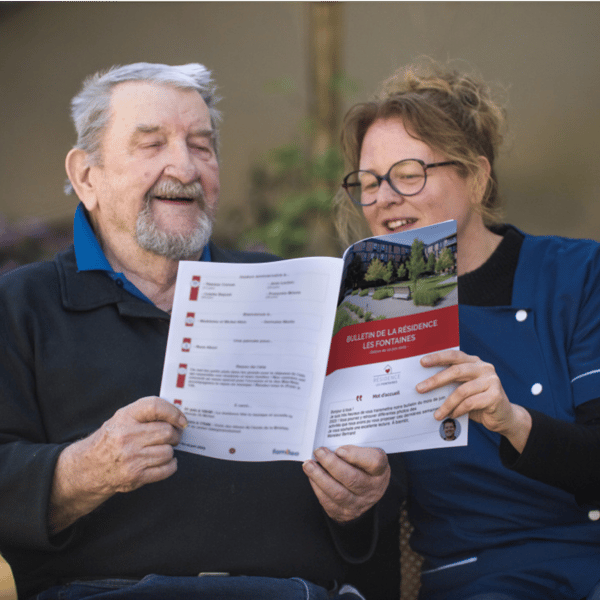 Personne âgée lisant sa gazette avec une aide-soignante