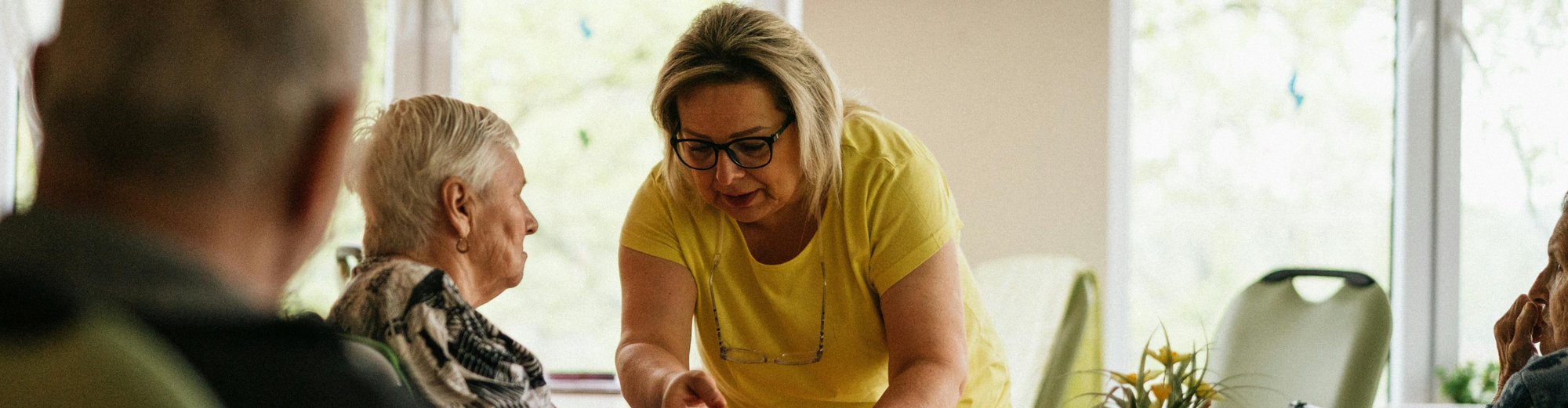 Aidante parlant avec une personne âgée assise