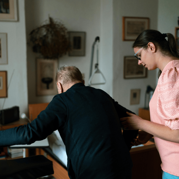 Aide-soignante soutenant une personne âgée pour se déplacer