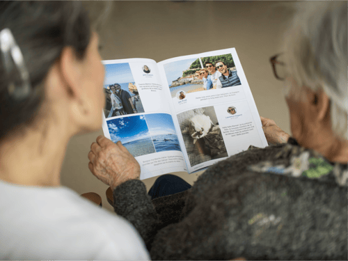 Soignante et résidente regardent leur gazette Famileo Soignante et résidente regardent leur gazette Famileo
