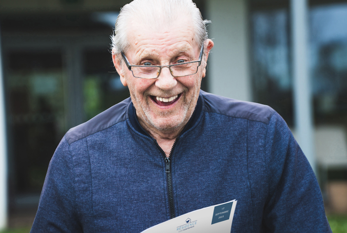 Un residente de un centro socio-sanitario feliz con su revista Famileo